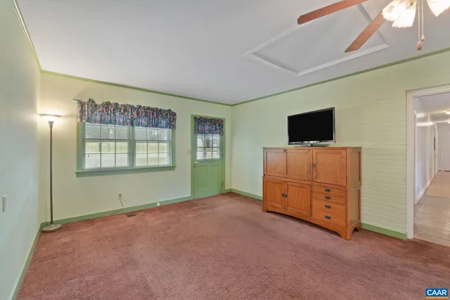 an empty room with furniture and a flat screen tv
