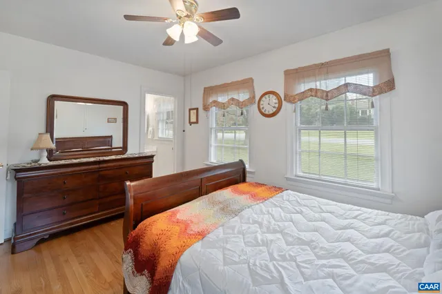 a bedroom with a bed and a dresser with wooden floor