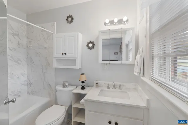 a bathroom with a sink vanity mirror and toilet