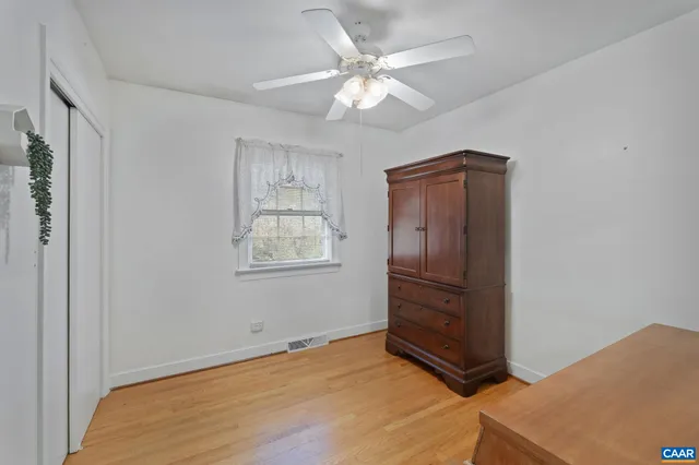 a view of an empty room with window and cabinet