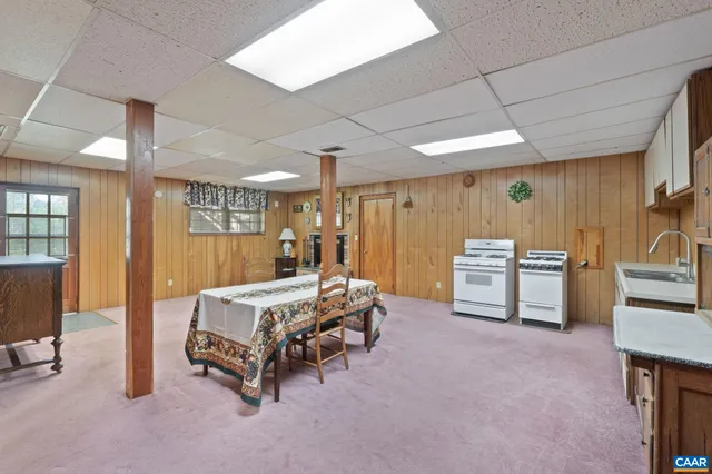 a spacious bedroom with a bed a table and chairs