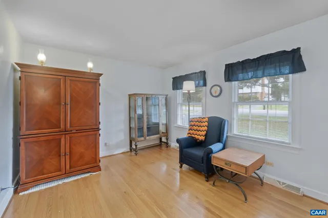 a living room with furniture and a refrigerator