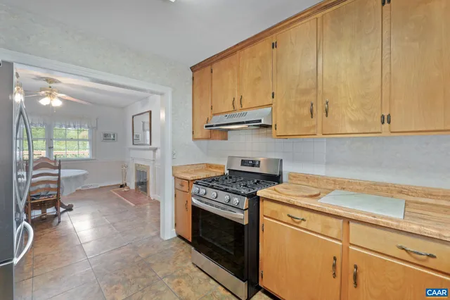 a kitchen with stainless steel appliances granite countertop a stove a sink and a white cabinets