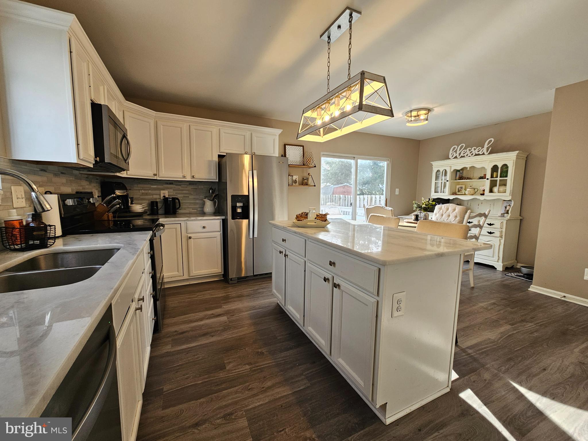 413 Cedar Grove Road Edgewater, MD 21037 - Photo 5 of 30 a kitchen with cabinets a sink a window and stainless steel appliances