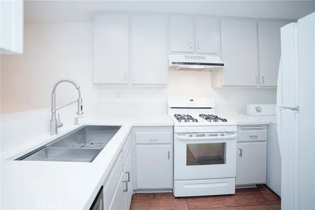 a kitchen with a stove top oven sink and cabinets