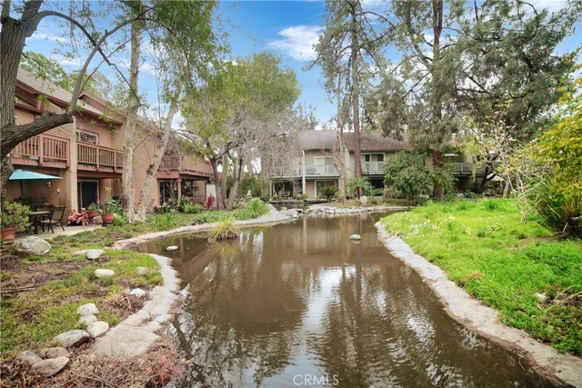 a view of swimming pool with lawn chairs and plants
