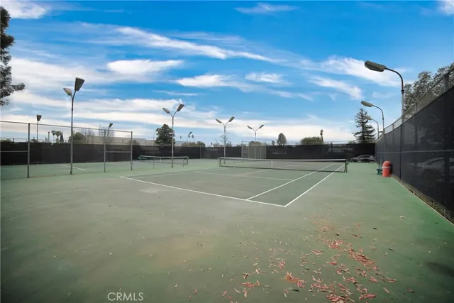a view of a tennis ground with large trees