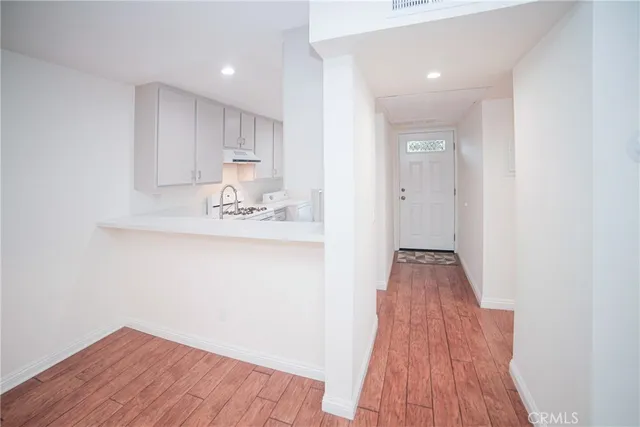 a view of kitchen with sink and refrigerator
