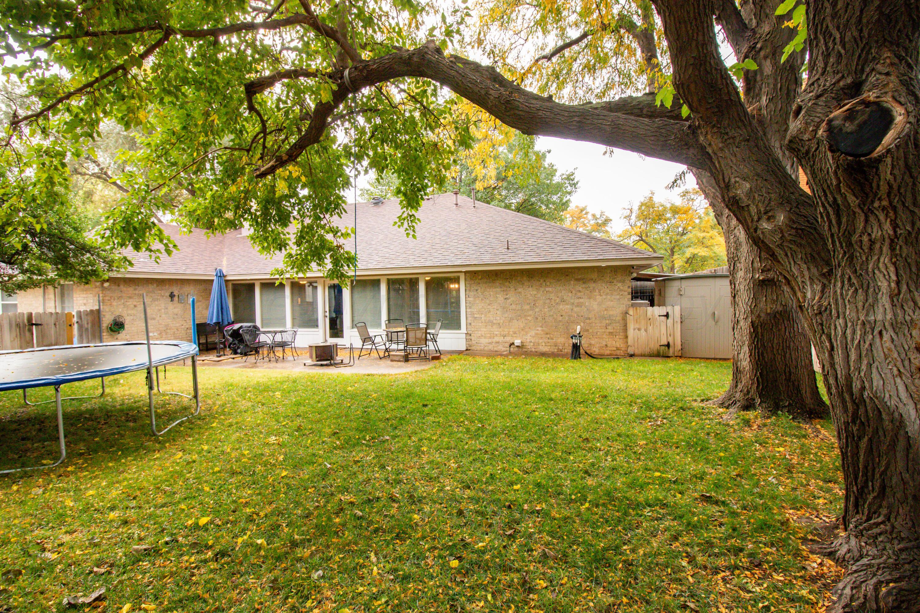 6704 Elmhurst Road Amarillo, TX 79106 - Photo 32 of 40 a view of house with outdoor seating and covered with trees