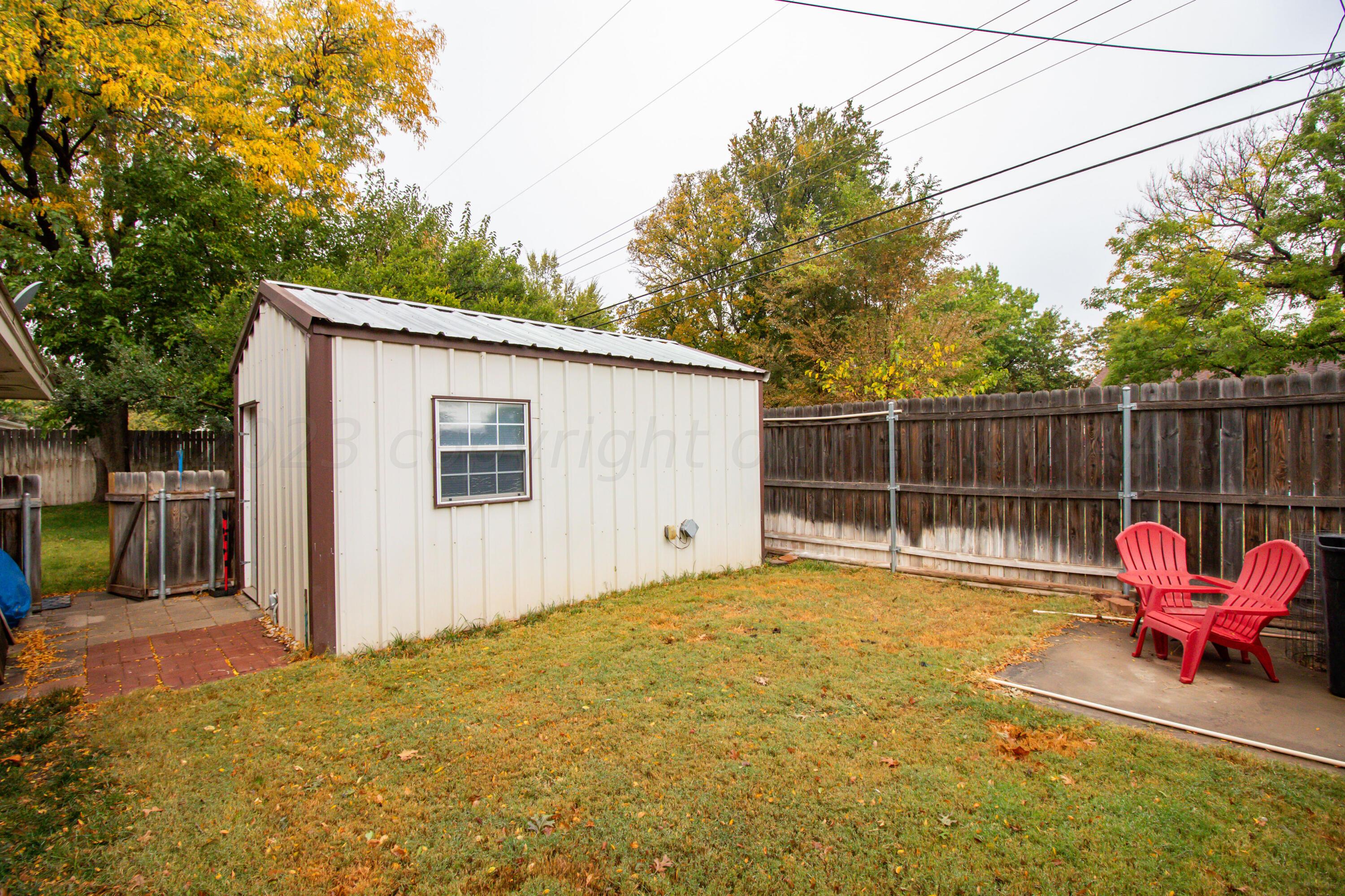 6704 Elmhurst Road Amarillo, TX 79106 - Photo 39 of 40 a view of backyard with small cabin and wooden fence