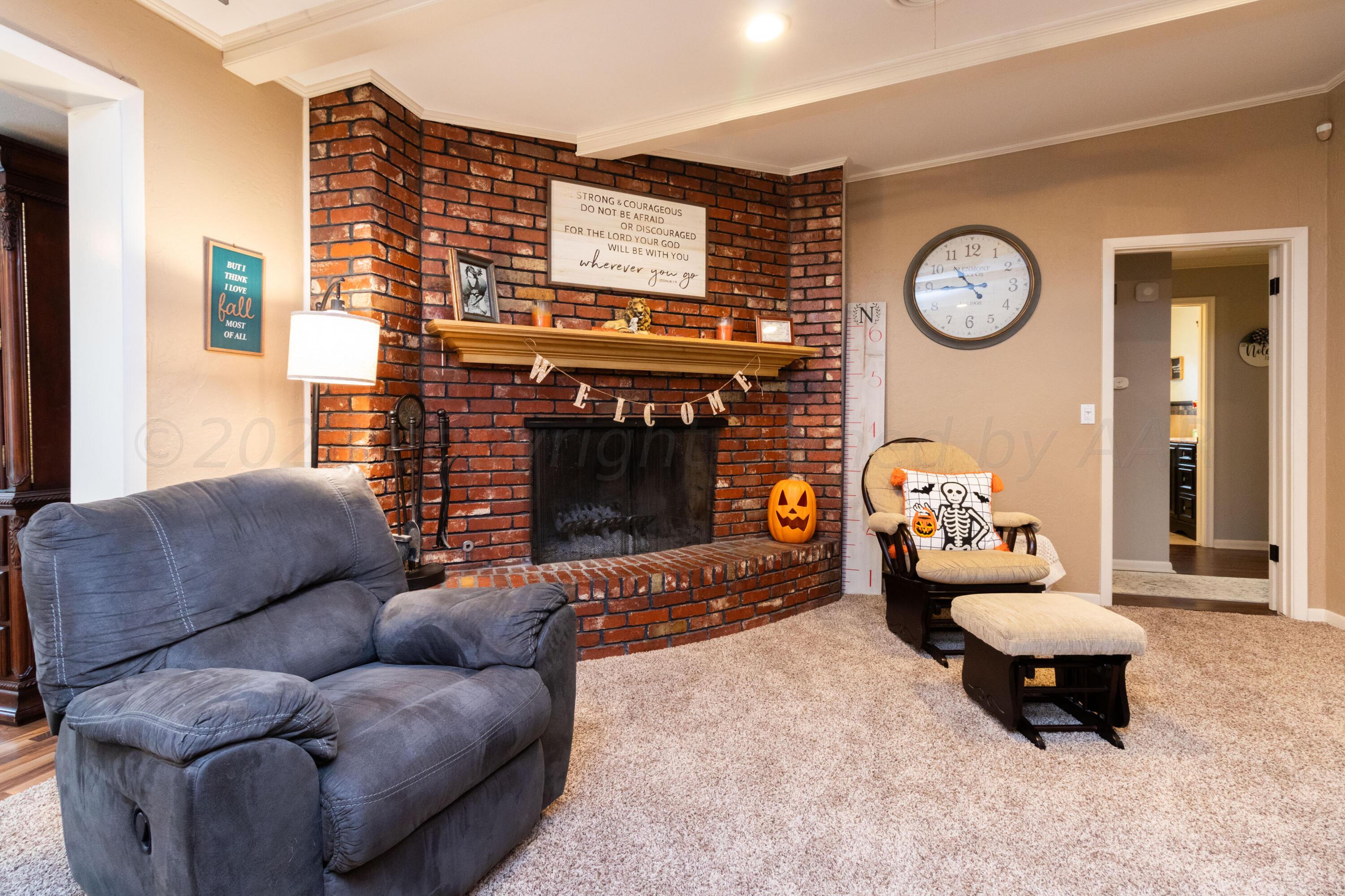 6704 Elmhurst Road Amarillo, TX 79106 - Photo 10 of 40 a living room with furniture a clock and a fireplace