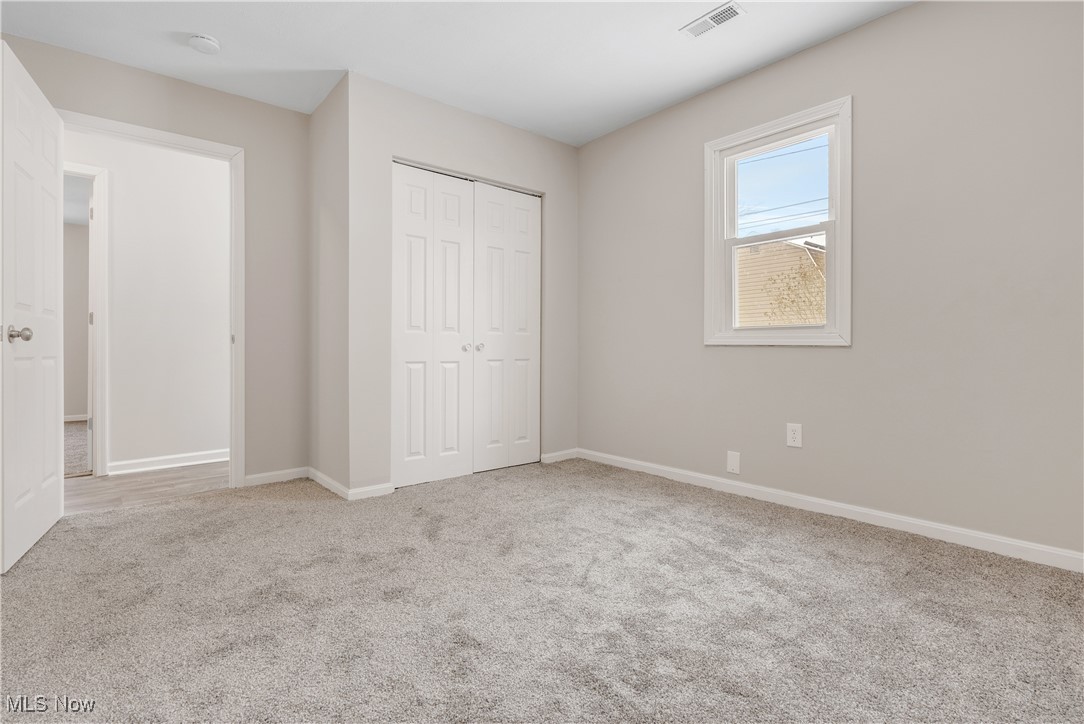 1893 Benjamin Road Madison, OH 44057 - Photo 9 of 23 Unfurnished bedroom with a closet, light colored carpet, visible vents, and baseboards