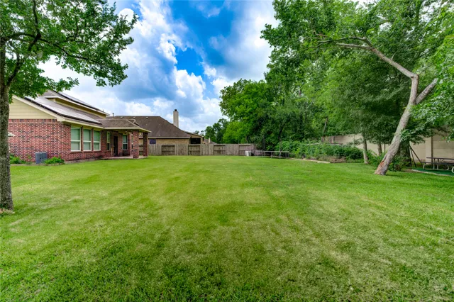 a view of a house with a big yard and large trees