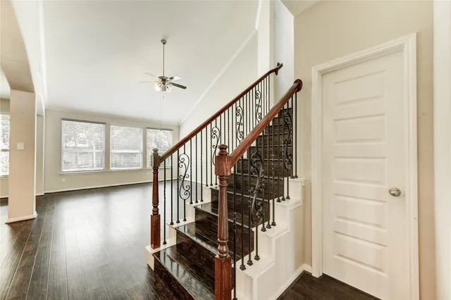 a view of hallway with stairs and wooden floor