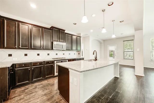 a kitchen with stainless steel appliances granite countertop a sink stove and cabinets