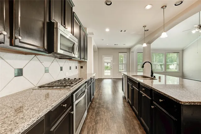 a kitchen with granite countertop a sink and a stove