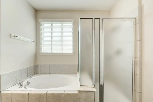 a white bath tub sitting next to a shower