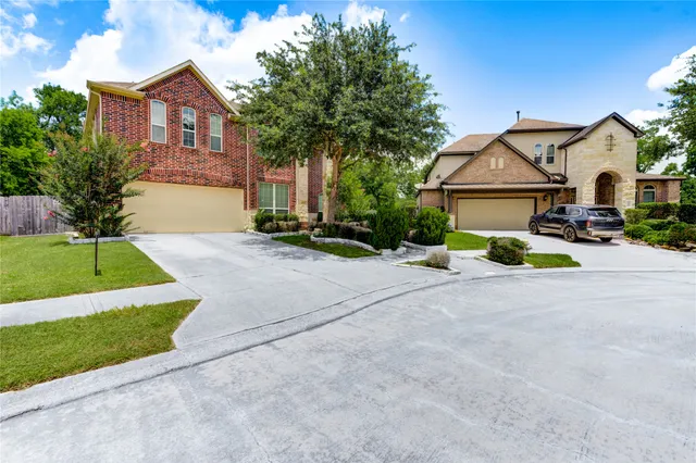 a view of a house with a yard and large tree
