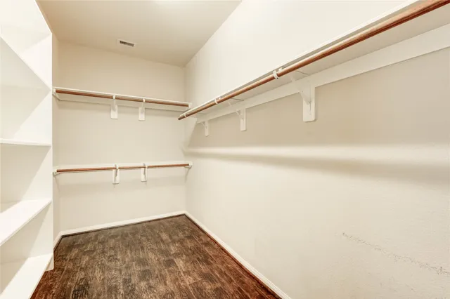 a view of walk in closet with empty racks