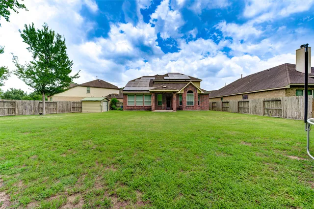 a front view of house with yard and trees in the background