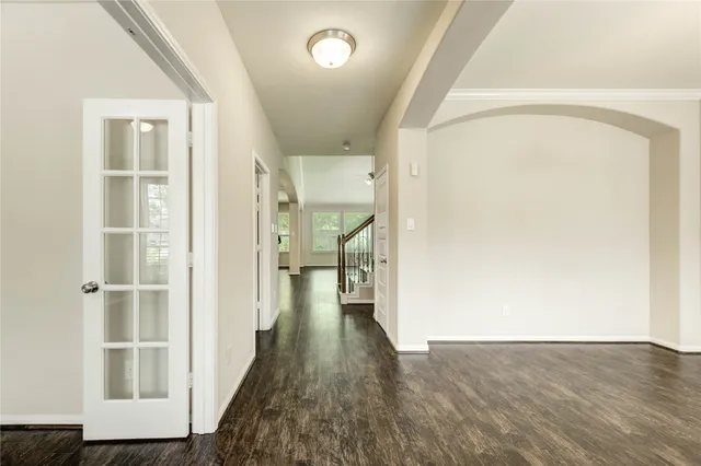 a view of a hallway with wooden floor and closet