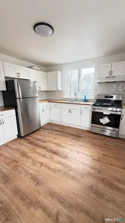 a kitchen with granite countertop a refrigerator and a stove top oven