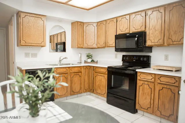 a kitchen with stainless steel appliances granite countertop white cabinets a stove top oven a sink and dishwasher