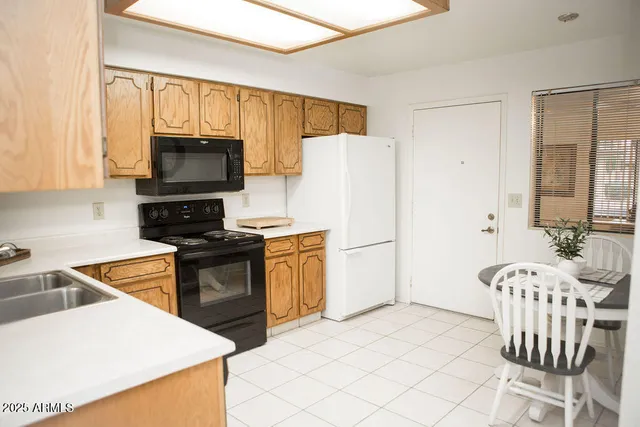 a kitchen with stainless steel appliances a refrigerator stove microwave and white cabinets