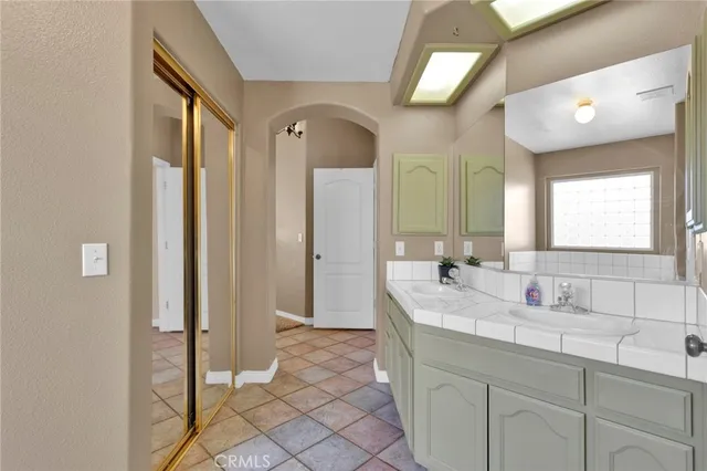 a bathroom with a double vanity sink mirror and next to a window