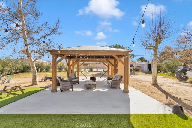 a view of a patio with table and chairs potted plants with wooden floor and fence