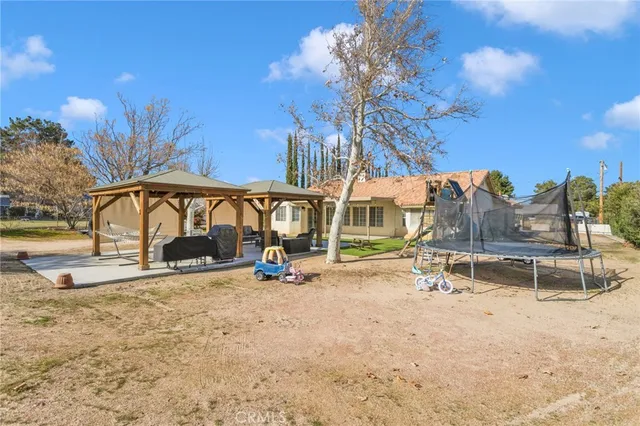 a view of a house with backyard and sitting area