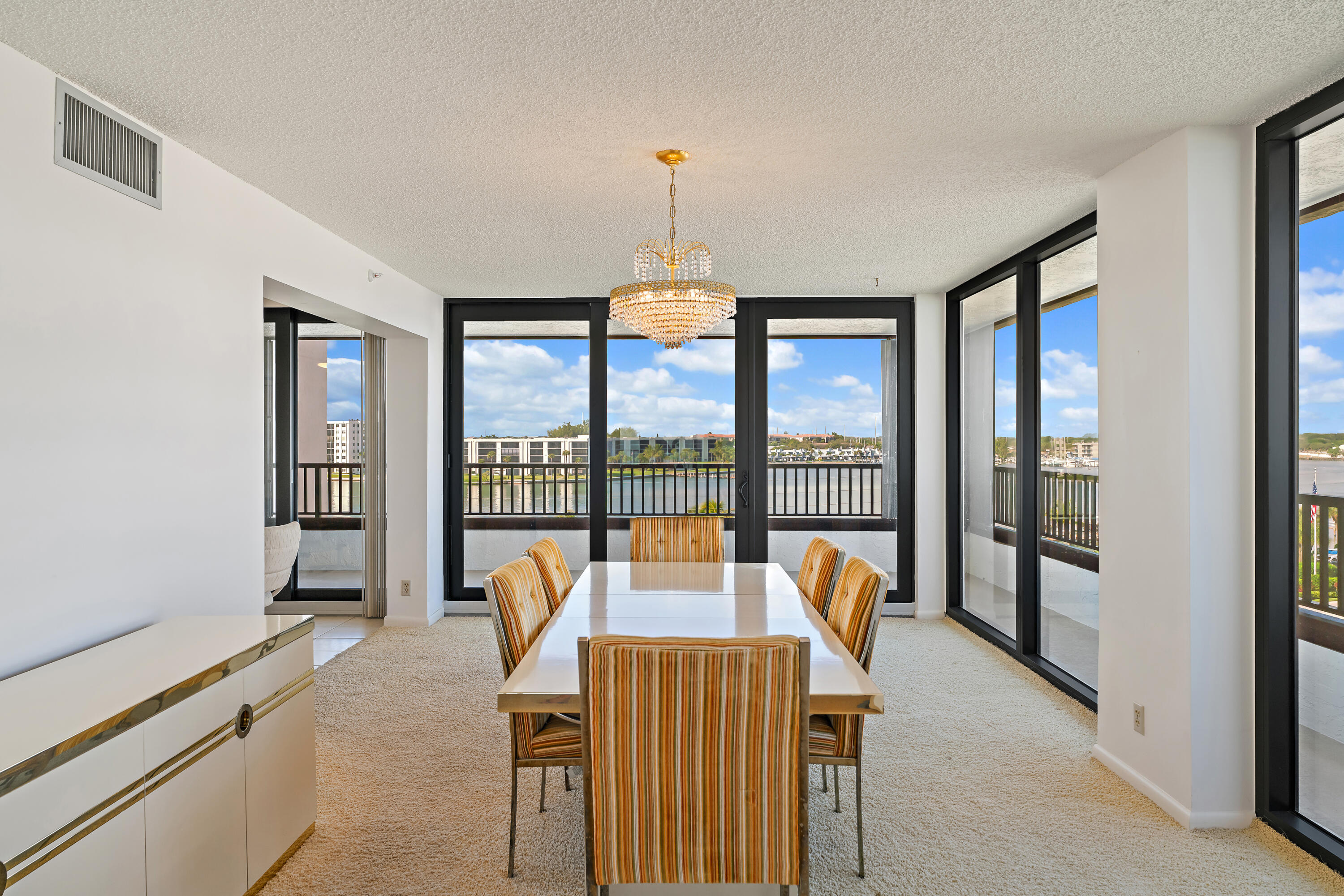19900 South Beach Road, Unit 601 Jupiter, FL 33469 - Photo 24 of 84 a dining room with furniture a chandelier and large window
