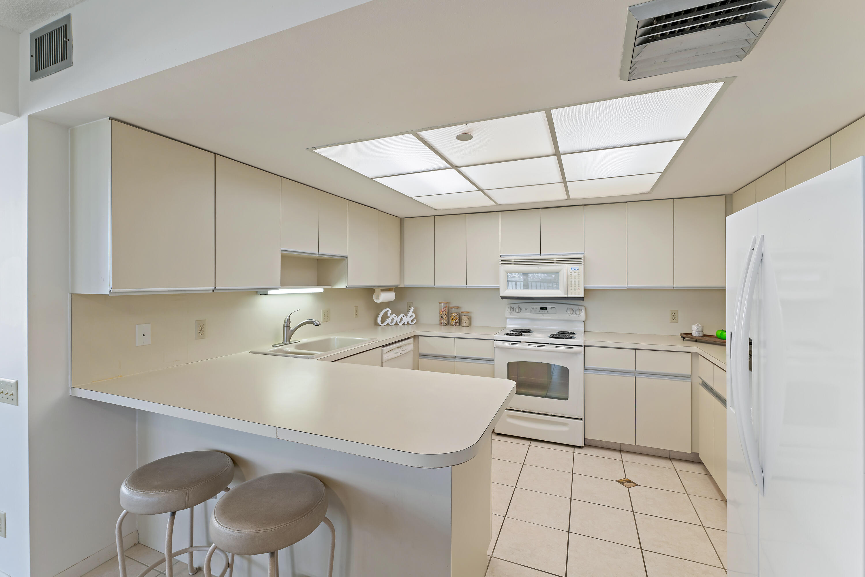 19900 South Beach Road, Unit 601 Jupiter, FL 33469 - Photo 31 of 84 a kitchen with a sink a stove cabinets dining table and chairs