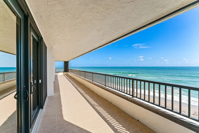 a living room with furniture floor to ceiling window and wooden floor