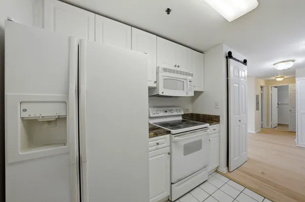a kitchen with white cabinets and white appliances
