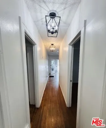 a view of a hallway with wooden floor and closet