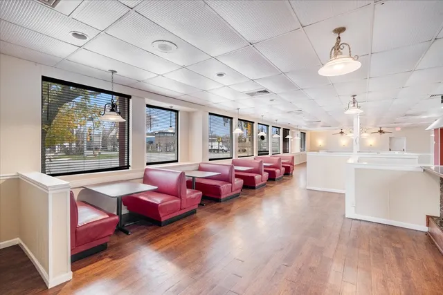 a living room with furniture kitchen view and a wooden floor