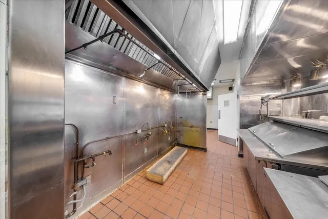 a kitchen with stainless steel appliances granite countertop a sink a stove and a refrigerator