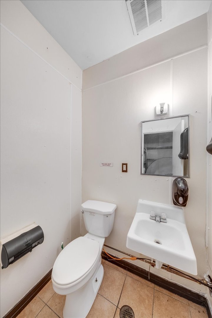 2312 West Springfield Avenue Champaign, IL 61821 - Photo 39 of 48 a bathroom with a sink a toilet and mirror