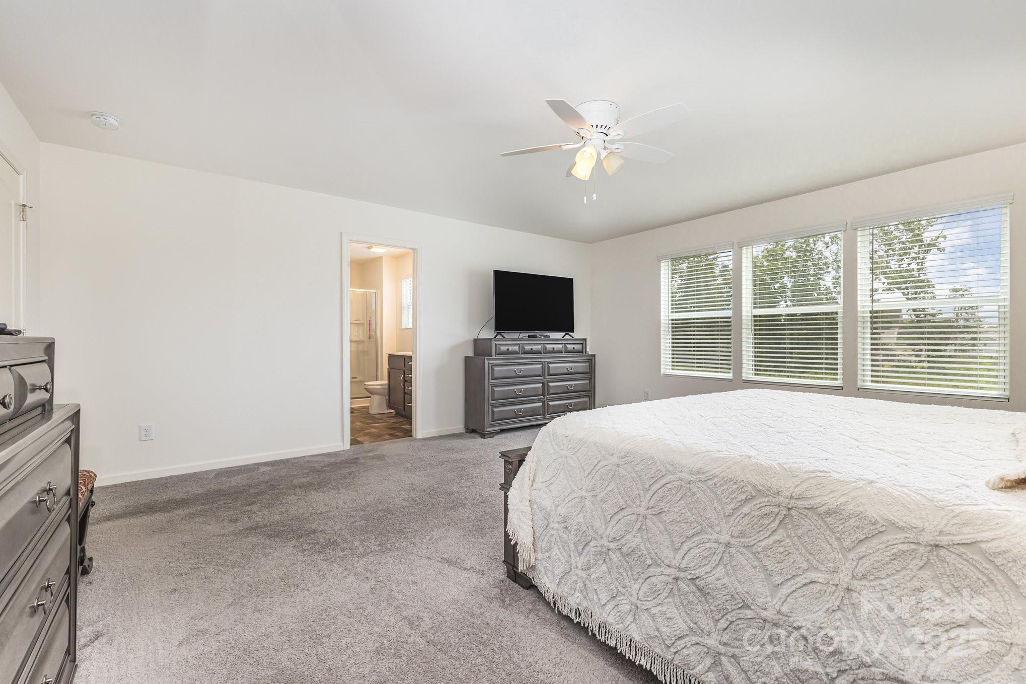 12926 Hill Pine Road Midland, NC 28107 - Photo 17 of 30 a spacious bedroom with a large bed and a flat screen tv