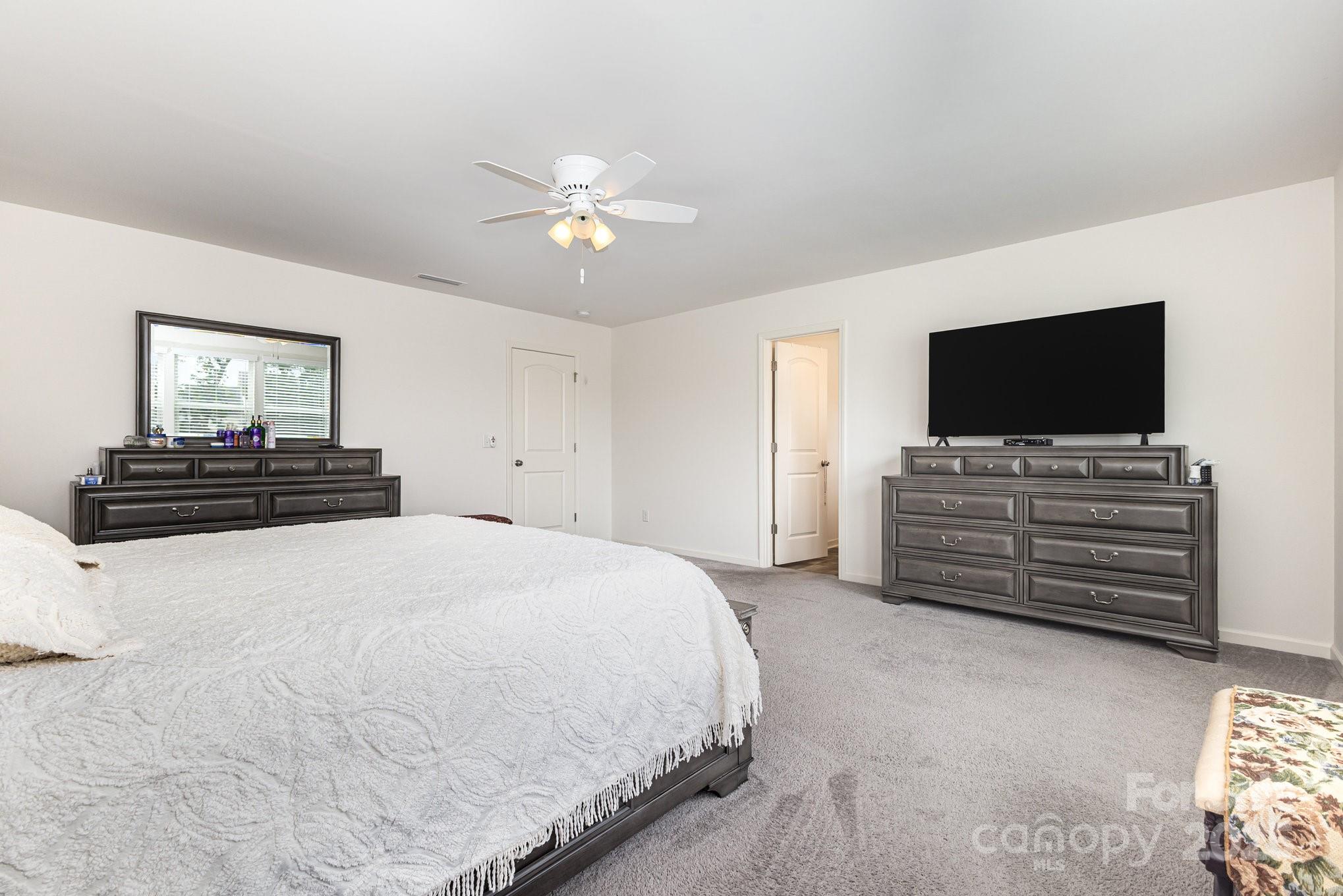 12926 Hill Pine Road Midland, NC 28107 - Photo 18 of 30 a bedroom with a bed and a flat screen tv