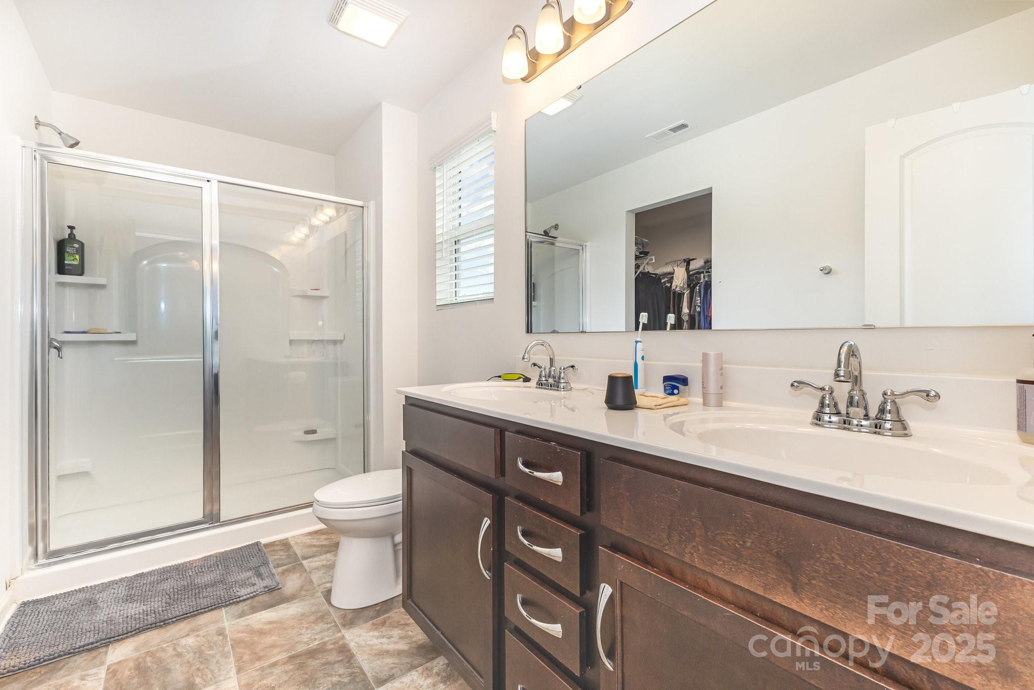 12926 Hill Pine Road Midland, NC 28107 - Photo 19 of 30 a spacious bathroom with a double vanity sink toilet mirror and shower
