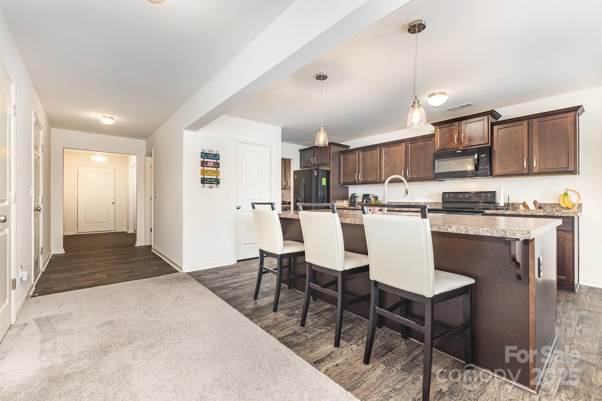 12926 Hill Pine Road Midland, NC 28107 - Photo 6 of 30 a living room with stainless steel appliances kitchen island granite countertop a dining table chairs and a refrigerator