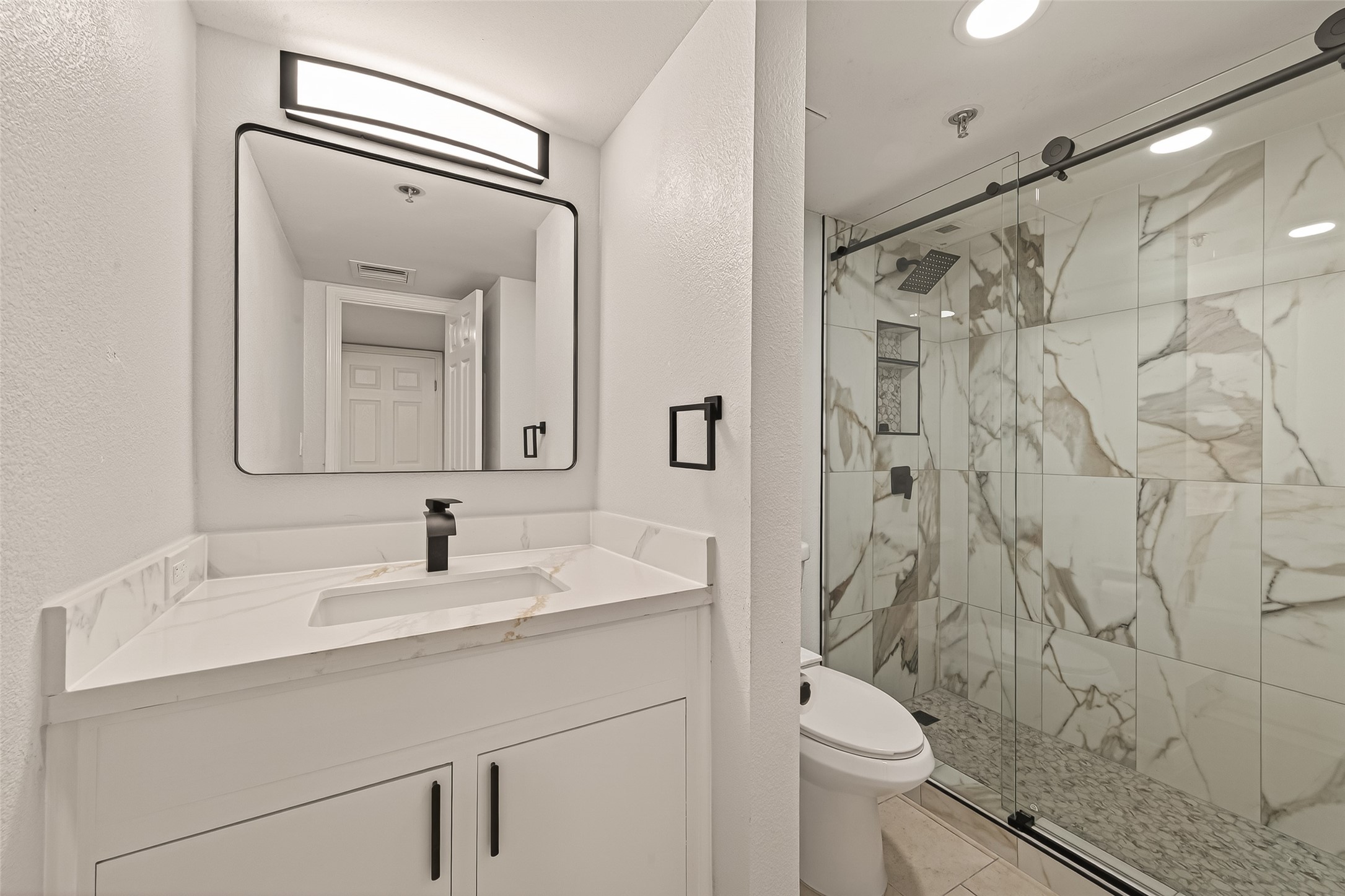 3525 Sage Road, Unit 1405 Houston, TX 77056 - Photo 24 of 37 a bathroom with a toilet a sink and mirror