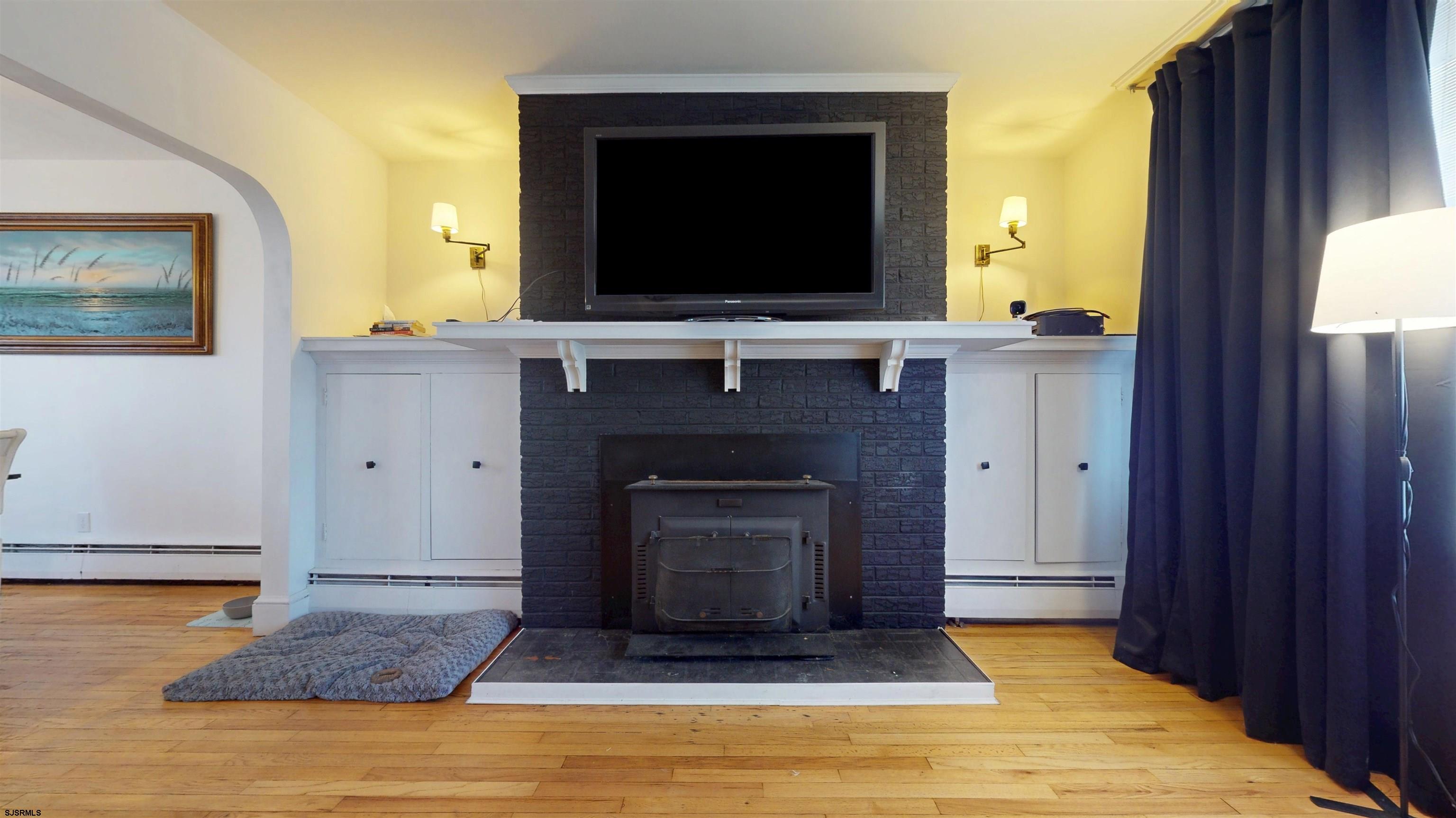 2300 Shore Road Linwood, NJ 08221 - Photo 11 of 50 a living room with a fireplace and a flat screen tv