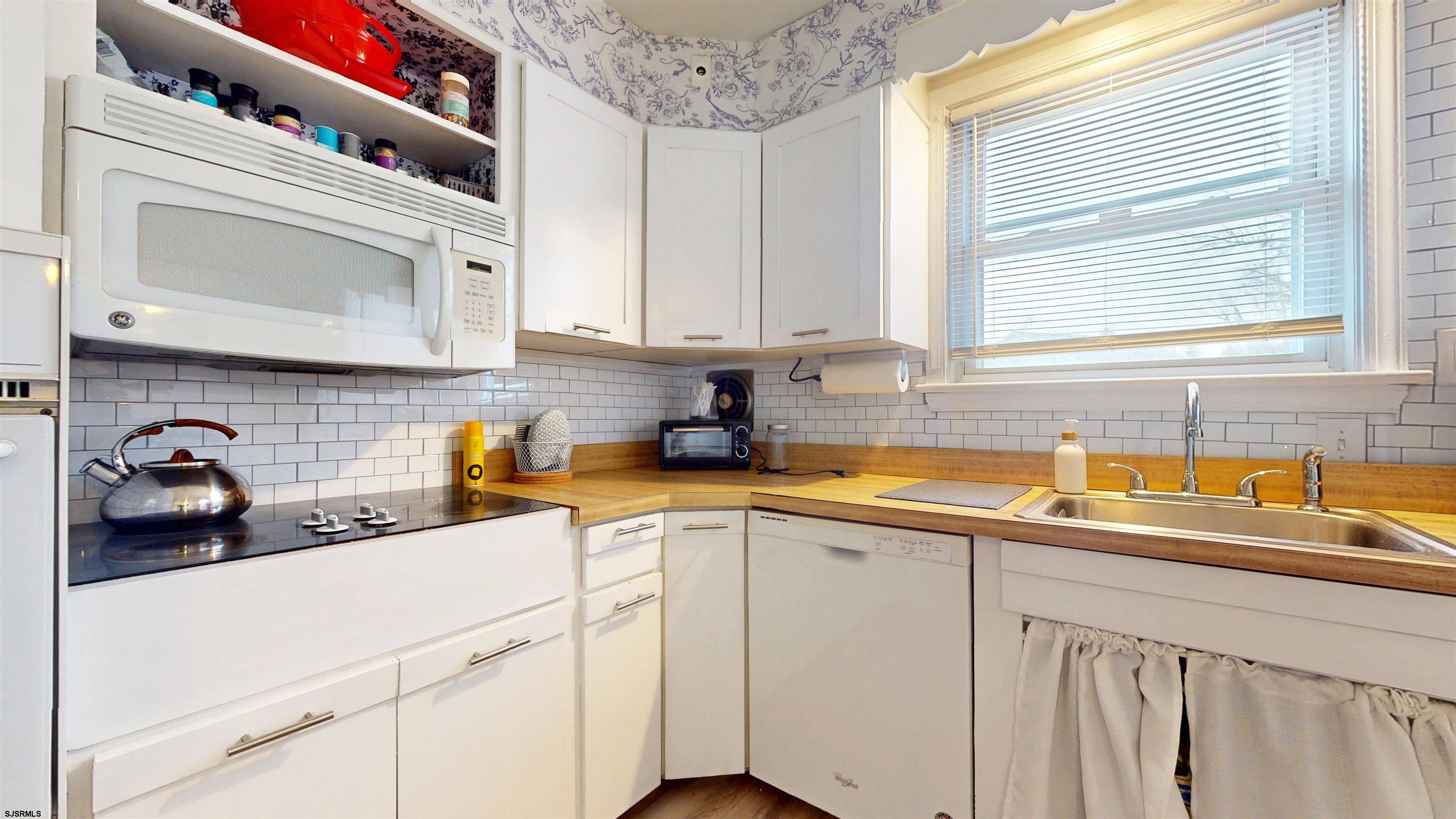 2300 Shore Road Linwood, NJ 08221 - Photo 29 of 50 a kitchen with white cabinets a sink and dishwasher next to a window