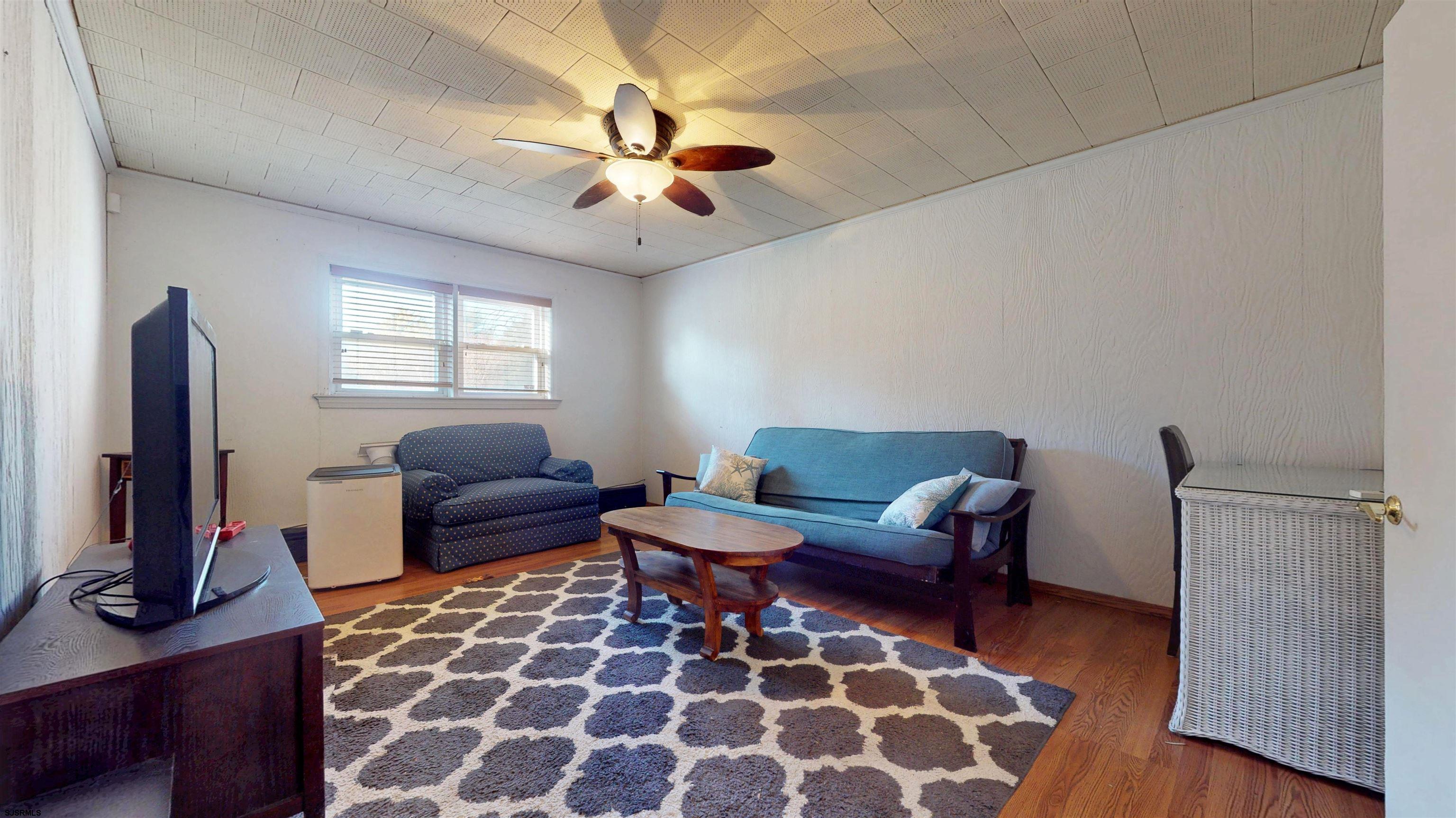 2300 Shore Road Linwood, NJ 08221 - Photo 32 of 50 a living room with furniture a flat screen tv and a window