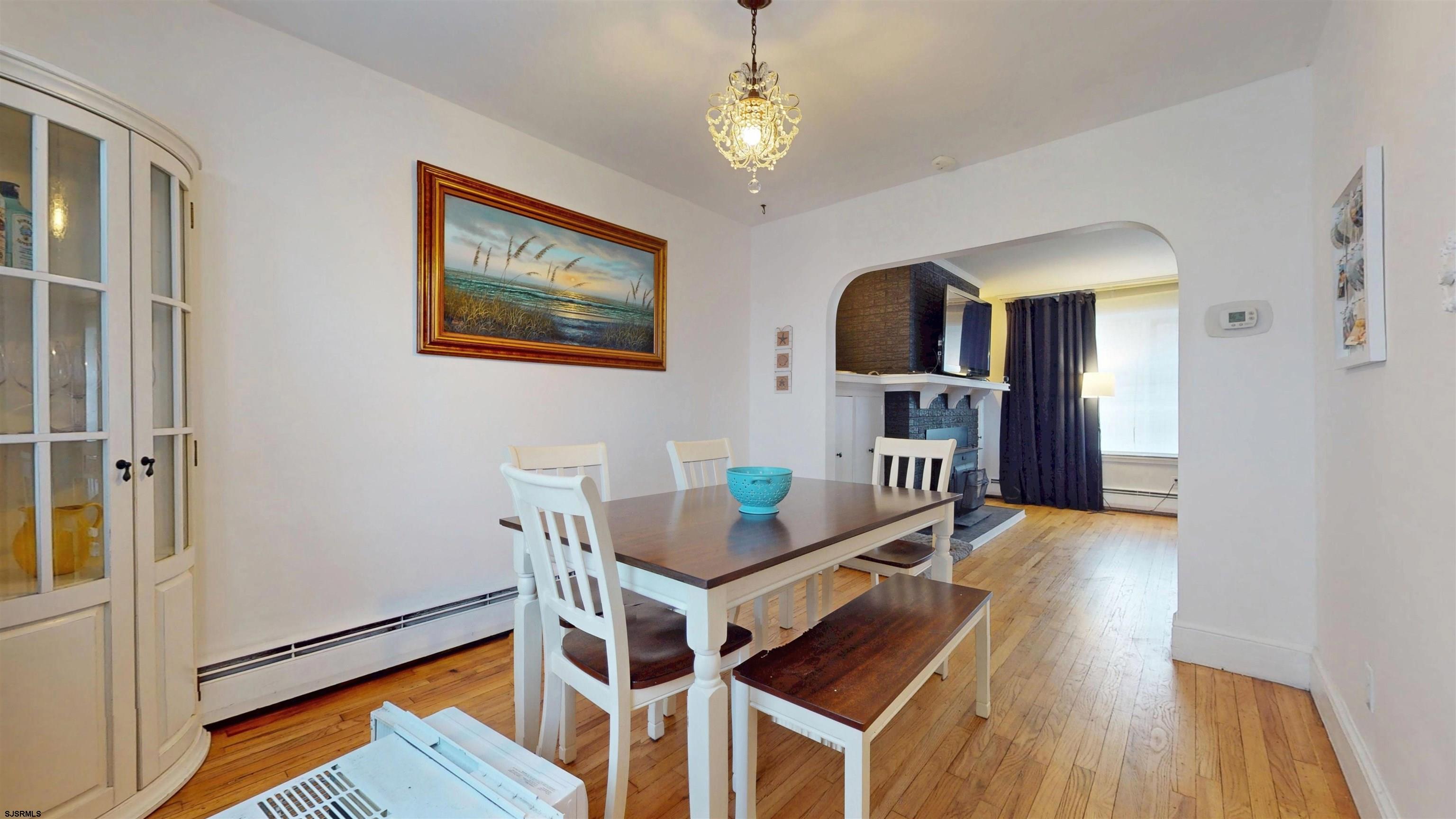 2300 Shore Road Linwood, NJ 08221 - Photo 6 of 50 a dining room with wooden floor a chandelier a wooden table and chairs