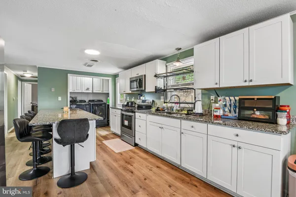 a kitchen with granite countertop a white cabinets and window