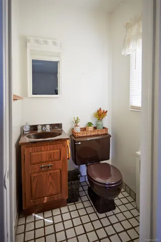 a bathroom with a toilet a sink and a mirror